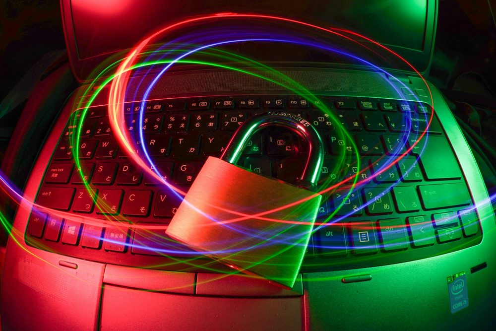 Padlock on a laptop keyboard with light trails